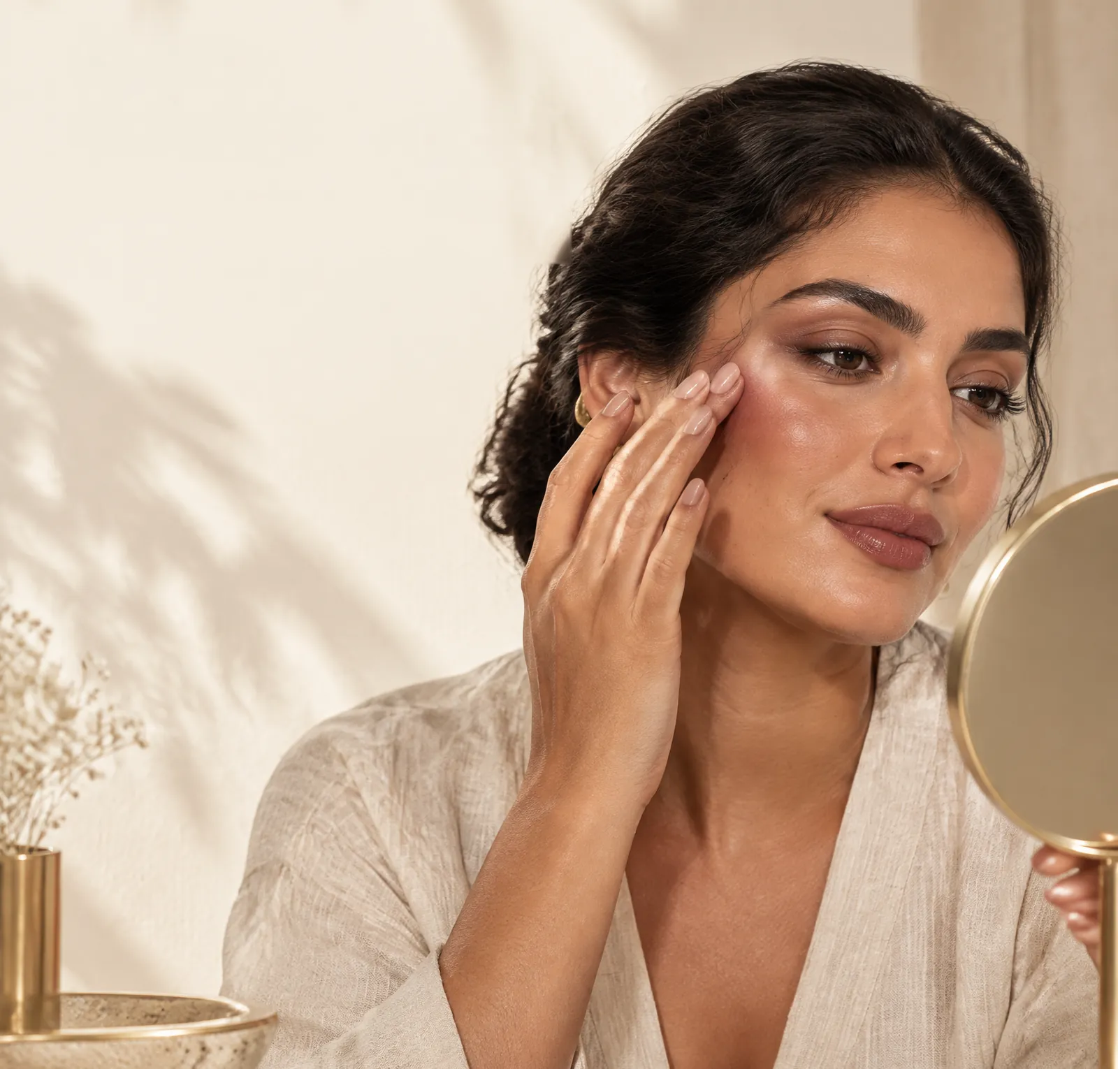 Model applying blush high on the cheek